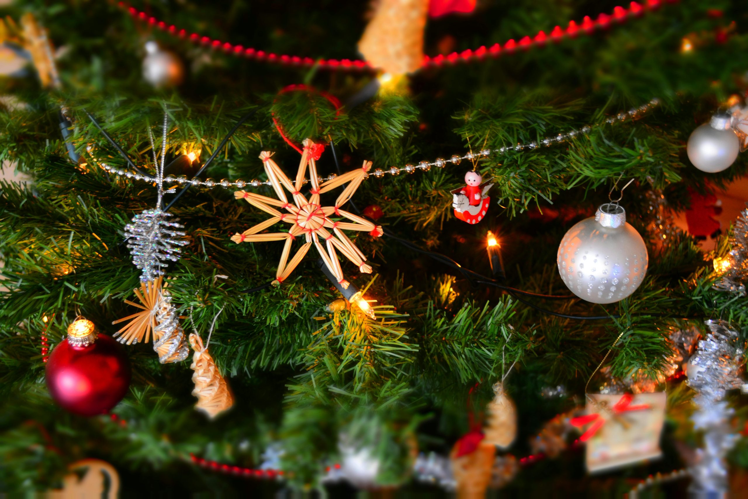 Close-up of a decorated Christmas tree with lights and ornaments, showcasing holiday spirit.